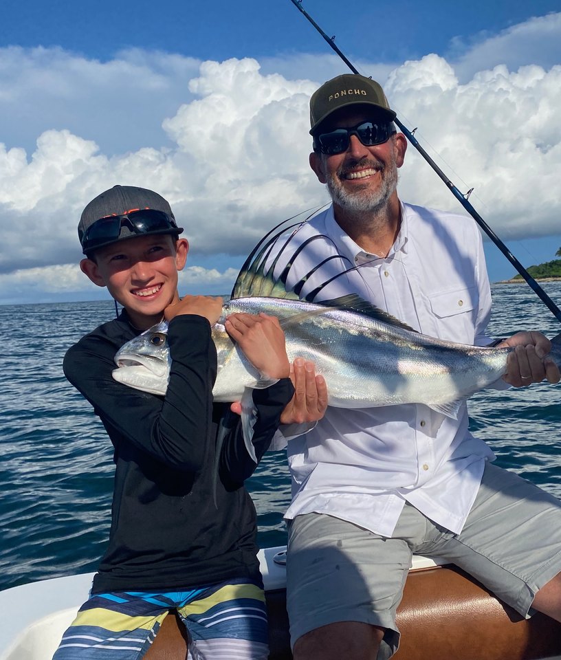 Jason Golod and his son on the water with a roosterfish